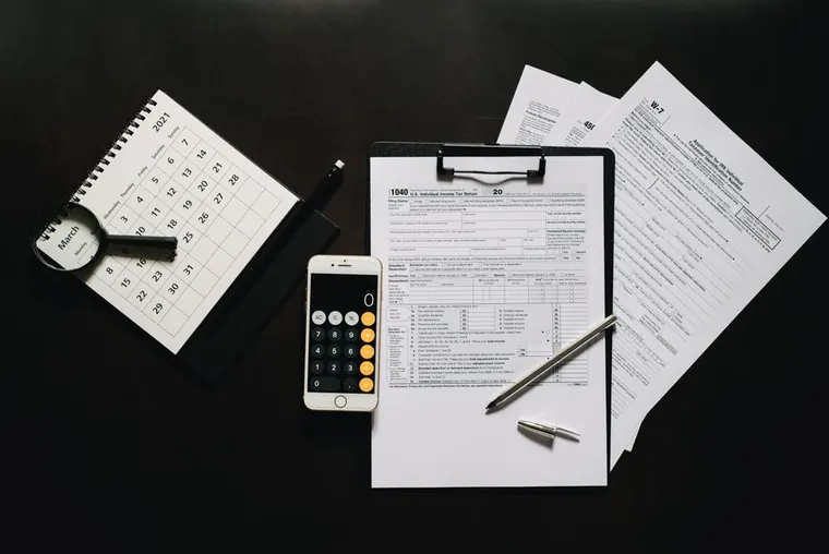 calculator and tax forms on desk