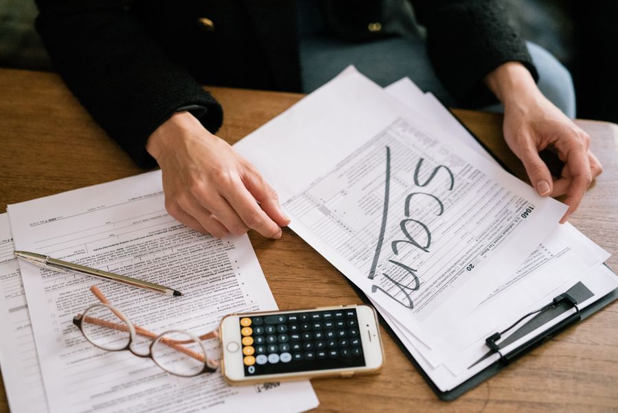 person reviewing papers with calculator